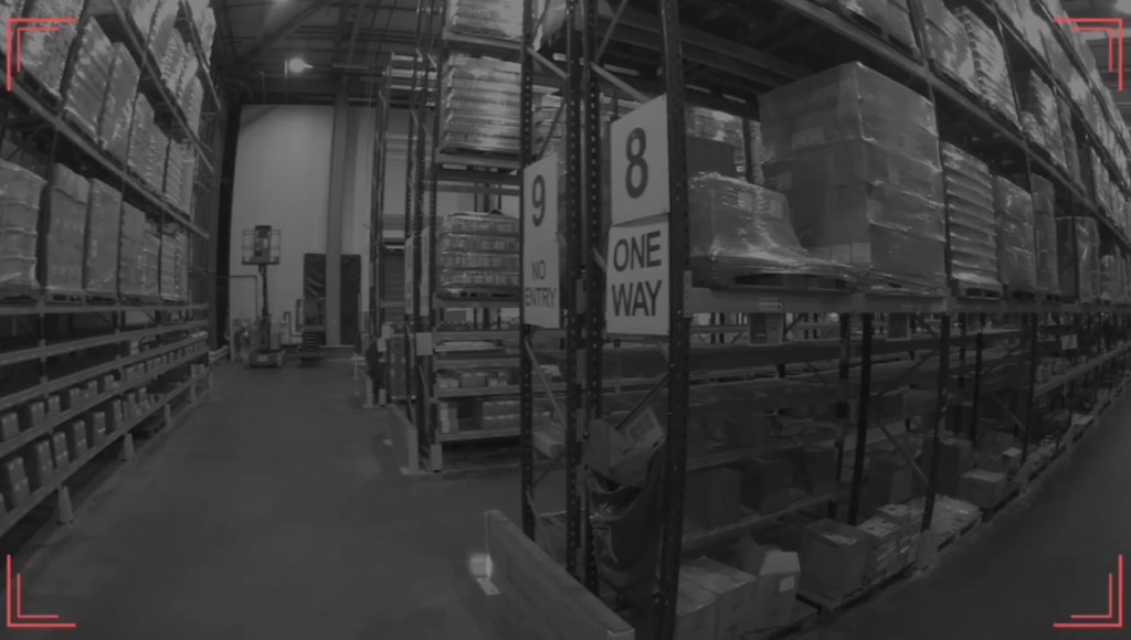 Monochrome warehouse aisle camera view with rack landmarks and computer-vision corner overlays