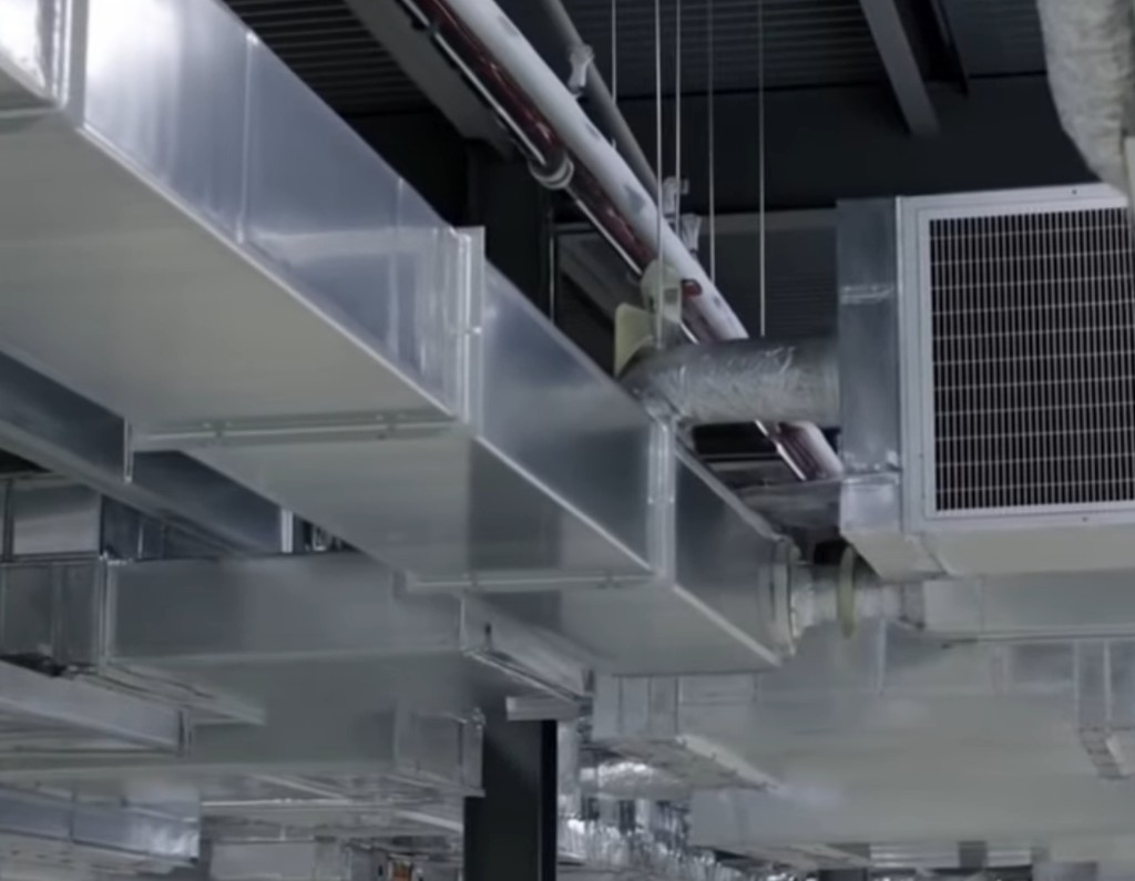 Industrial HVAC ductwork and exhaust units over a plant ceiling